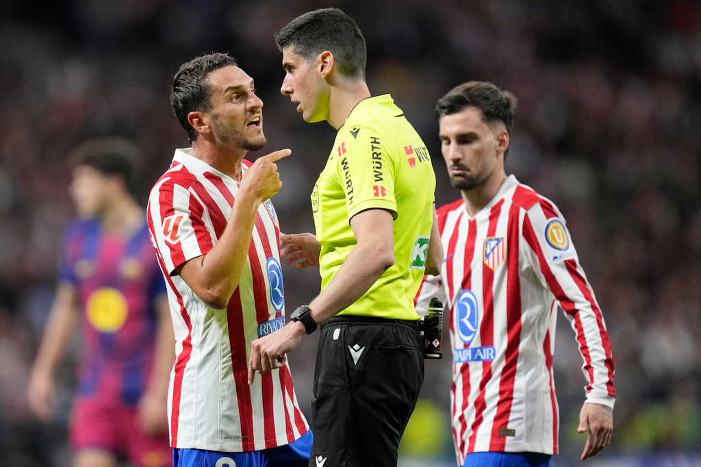 Referee Mateo Busquets speaks to Atletico Madrid's Koke during a La Liga soccer match between Atletico Madrid and Barcelona in Madrid, Spain, Saturday, April 4, 2026. (AP Photo/Bernat Armangue)