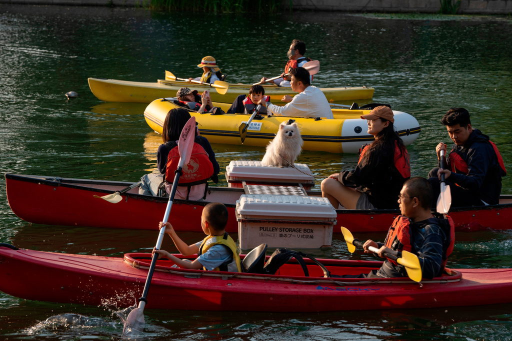 People paddle along a scenic river in Beijing, Friday, May 8, 2026. (AP Photo/Ng Han Guan)