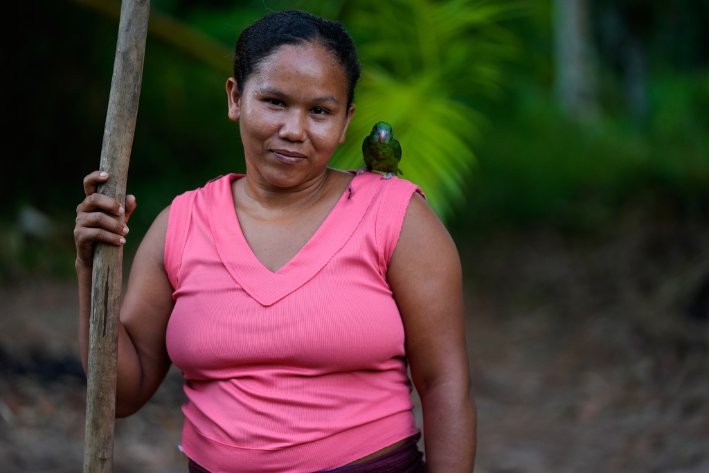 Adria poses for a photo with her little mascot at the backyard of her home in Itacoa Miri, Brazil, Tuesday, Nov. 18, 2025. (AP Photo/Fernando Llano)
