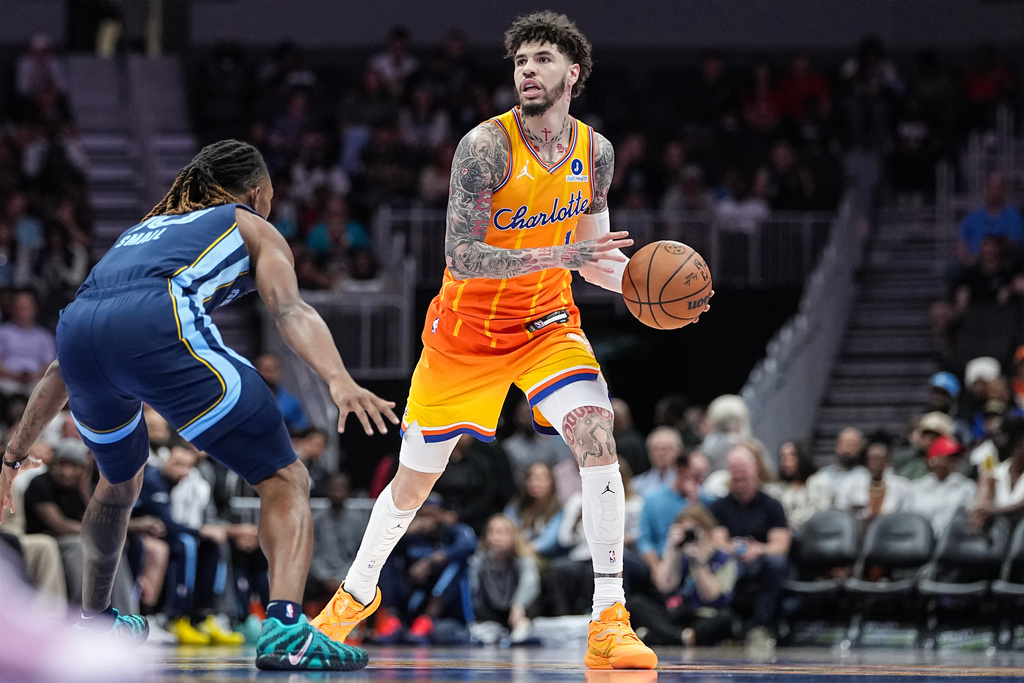 Charlotte Hornets guard LaMelo Ball (1) brings the ball up court against Memphis Grizzlies guard Javon Small (10) during the first half of an NBA basketball game Saturday, March 21, 2026, in Charlotte, N.C. (AP Photo/Matt Kelley)
