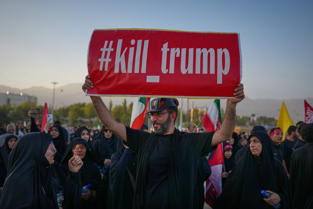 A man holds a sign reading "#kill_trump" as mourners gather for funeral ceremonies for slain Iranian Supreme Leader Ayatollah Ali Khamenei and members of his family at the Imam Khomeini Mosalla Grand Mosque in Tehran, Iran, Sunday, July 5, 2026. (AP Photo/Altaf Qadri)