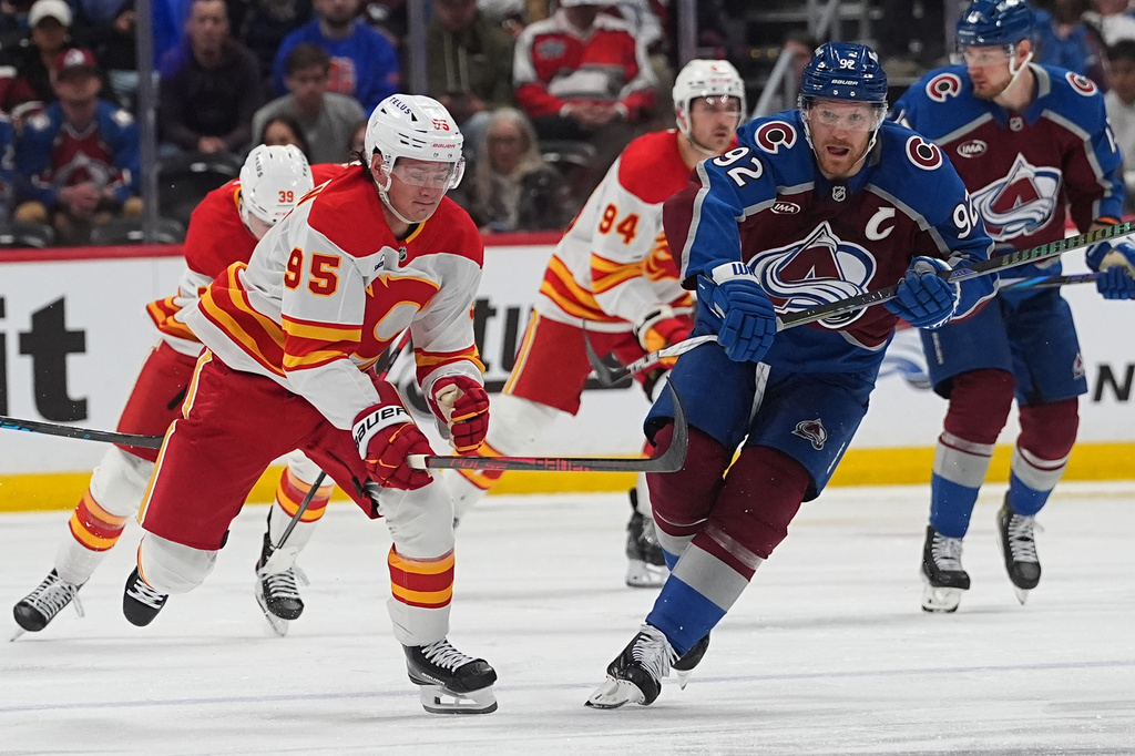 Calgary Flames left wing Victor Olofsson, front left, pursues the puck with Colorado Avalanche left wing Gabriel Landeskog (92) in the second period of an NHL hockey game Thursday, April 9, 2026, in Denver. (AP Photo/David Zalubowski)