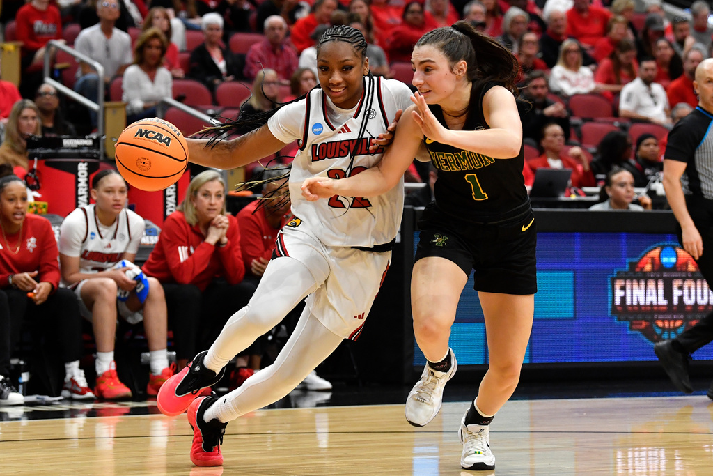 Louisville guard Tajianna Roberts (22) attempts to drive past Vermont guard Jacklynn Hosier (1) during the second half in the first round of the NCAA college basketball tournament, Saturday, March 21, 2026 in Louisville, Ky. (AP Photo/Timothy D. Easley)