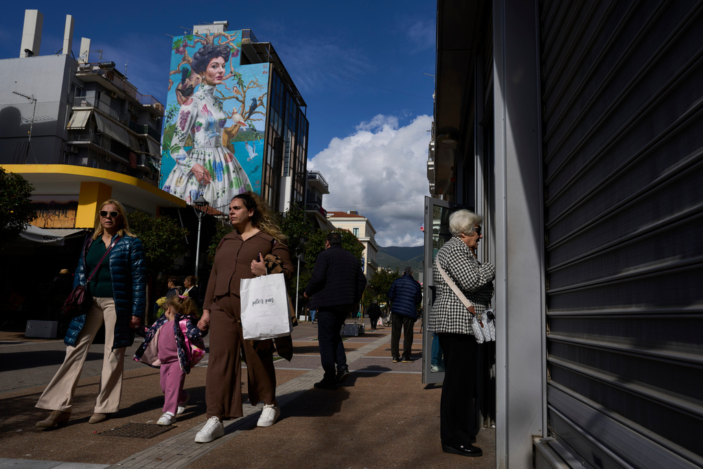 Pedestrians walk in front of the mural entitled 'Kalamata' depicting opera legend Maria Callas by artist Kleomenis Kostopoulos in Kalamata town, about 240 kilometers (150 miles) southwest of Athens, Monday, Feb. 9, 2026. (AP Photo/Petros Giannakouris)