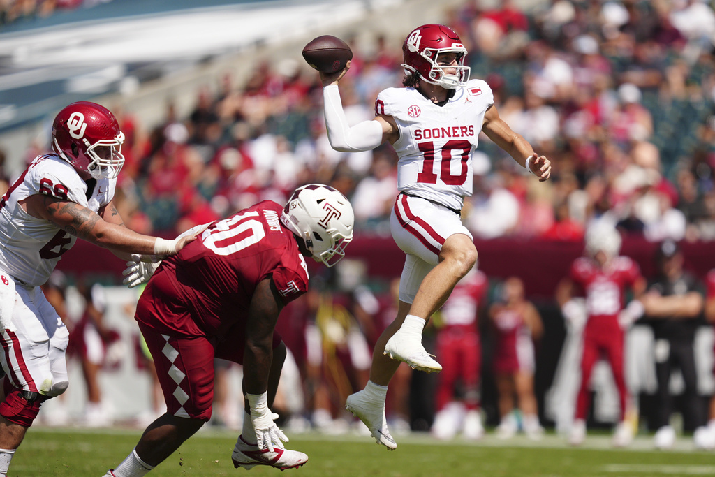 Oklahoma quarterback John Mateer (10) leaps as he throws the ball during the first half of an NCAA college football game against Temple, Saturday, Sept. 13, 2025, in Philadelphia. (AP Photo/Derik Hamilton)