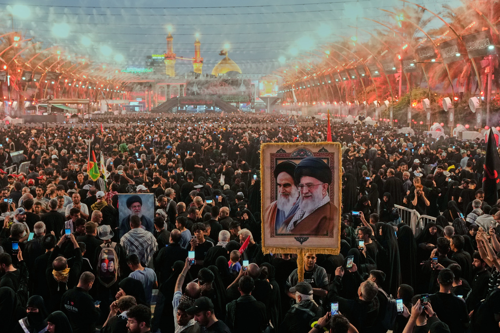 Shiite worshipers carrying a portrait of the late Iranian Supreme Leader Ayatollah Ali Khamenei and the late Iranian Leader Ayatollah Khomeini gather between the holy shrines of Imam Abbas and Imam Hussein during Arbaeen, marking the end of the 40-day mourning period following Ashoura, in Karbala, Iraq, Tuesday, Aug. 4, 2026. (AP Photo/Hadi Mizban)