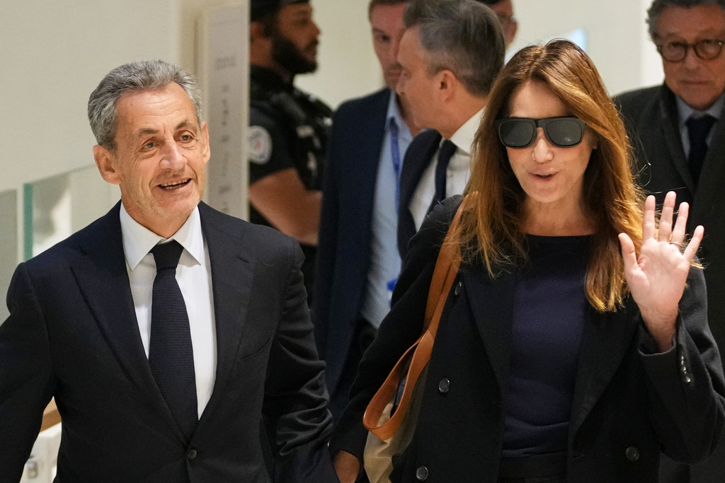 Former French President Nicolas Sarkozy, left, and his wife Carla Bruni, right, arrive at the courthouse, in Paris, France, Thursday, Sept. 25, 2025. (AP Photo/Christophe Ena)