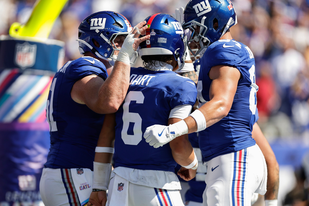 New York Giants quarterback Jaxson Dart (6) is congratulated by teammates after scoring a touchdown against the Los Angeles Chargers during the first quarter of an NFL football game, Sunday, Sept. 28, 2025, in East Rutherford, N.J. (AP Photo/Adam Hunger)