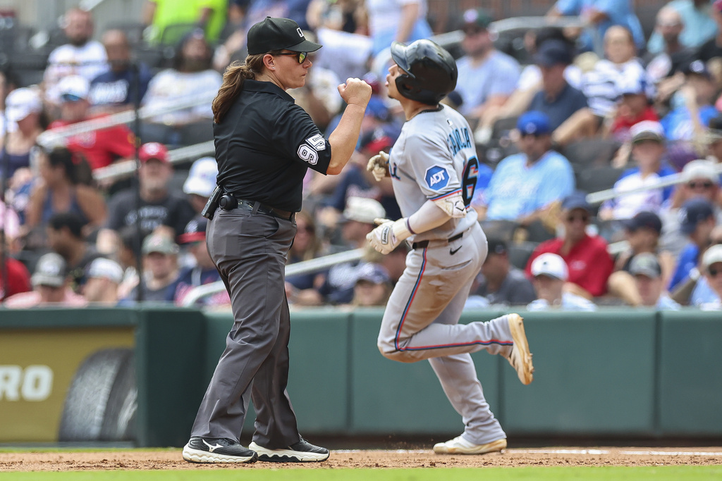 Umpire Jen Pawol, left, signals Miami Marlins' Javier Sanoja, right, out at first base in the eighth inning of the first baseball game of a doubleheader against the Atlanta Braves, Saturday, Aug. 9, 2025, in Atlanta. (AP Photo/Colin Hubbard)