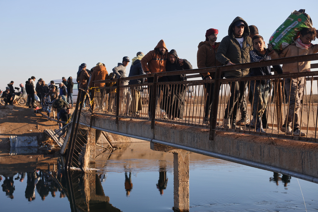FILE - Displaced Syrians at a river crossing near the village of Jarirat al Imam, in the eastern Aleppo countryside, near the front line with the Kurdish-led Syrian Democratic Forces in Deir Hafer, Syria, Thursday, Jan. 15, 2026. (AP Photo/Omar Albam)