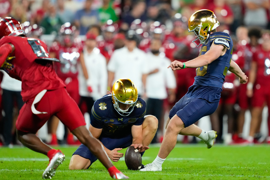 Notre Dame kicker Spencer Porath, right, boots a field goal under the hold of Jasper Scaife, left, during the first half of an NCAA college football game against Wisconsin, Sunday, Sept. 6, 2026, in Green Bay, Wis. (AP Photo/Kayla Wolf)