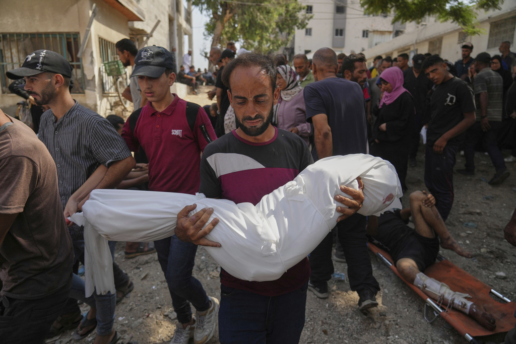 A Palestinian man carries the body of his 7-year-old nephew, Alaa Al-Toum, who, according to the family, was killed in an Israeli army airstrike last night, during his funeral at Shifa Hospital in Gaza City, Saturday, Aug. 16, 2025. (AP Photo/Jehad Alshrafi)