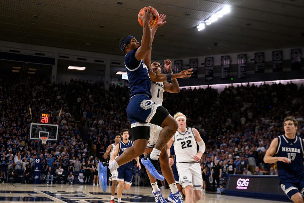 Nevada guard Tayshawn Comer, center left, drives to the basket guarded by Utah State guard Elijah Perryman, center right, during the first half of an NCAA college basketball game, Wednesday, Jan. 14, 2026, in Logan, Utah. (AP Photo/Tyler Tate)