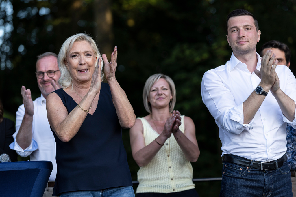 Far-right party National Rally president Jordan Bardella and far-right leader Marine Le Pen applaud during a rally in Lievin, northern France, Saturday, July 4, 2026. (AP Photo/Jean-Francois Badias)