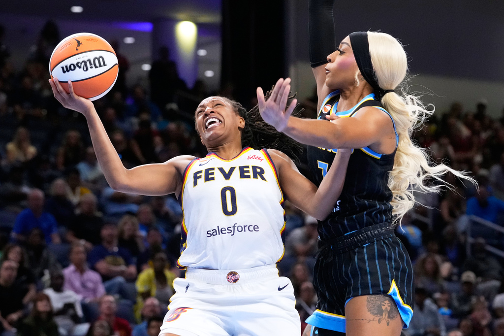 Indiana Fever guard Kelsey Mitchell, left, drives to the basket as Chicago Sky guard-forward DiJonai Carrington, right, defends during the first half of a WNBA basketball game Sunday, Aug. 23, 2026, in Chicago. (AP Photo/Nam Y. Huh)