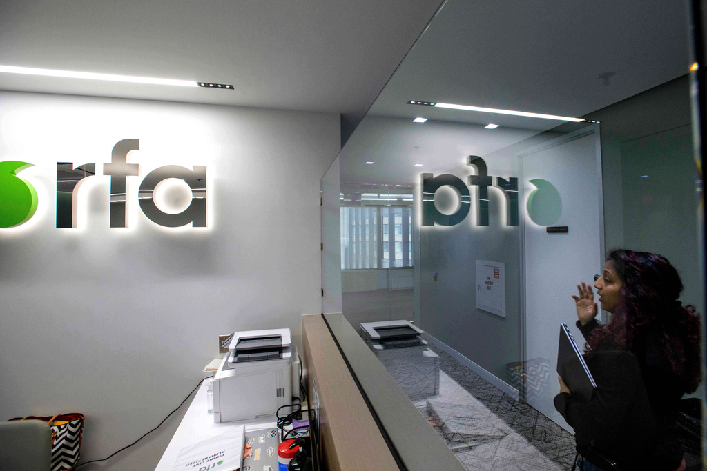 FILE - A woman walks past the empty receptionist desk at Radio Free Asia, April 1, 2025, in Washington. (AP Photo/Rod Lamkey, Jr., File)