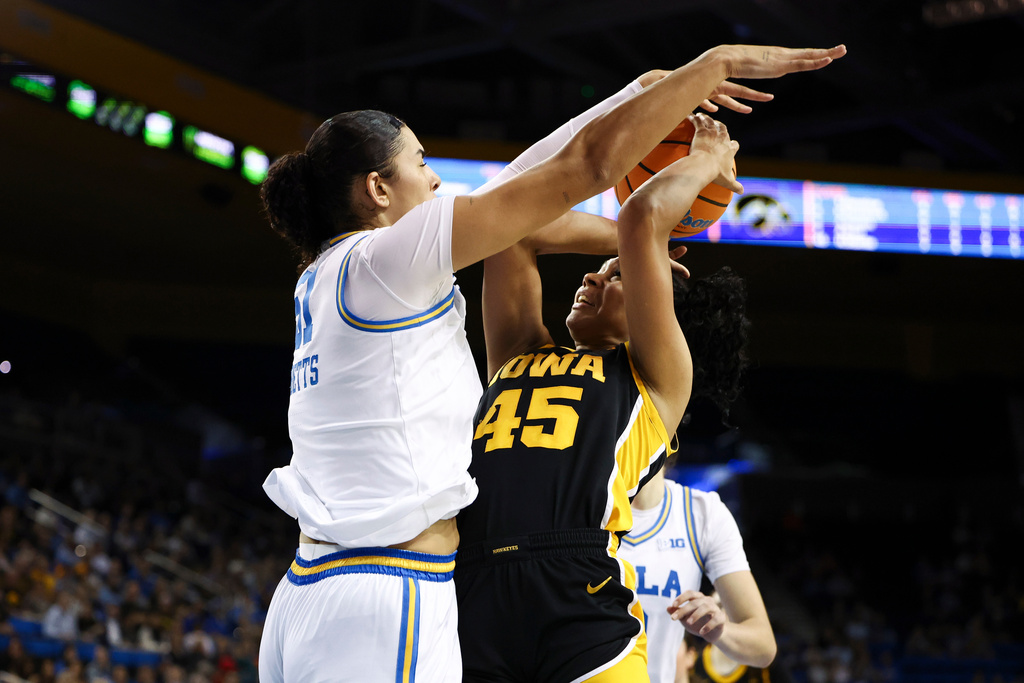 Iowa forward Hannah Stuelke (45) draws a foul against UCLA center Lauren Betts, left, during the first half of an NCAA college basketball game, Sunday, Feb. 1, 2026, in Los Angeles. (AP Photo/Jessie Alcheh)