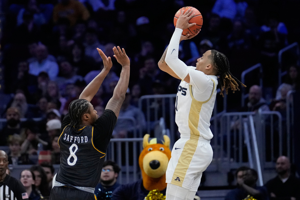Akron guard Shammah Scott, right, shoots over Kent State guard Morgan Safford (8) ib the second half of a basketball game in the semifinals of the Mid-American Conference tournament, Friday, March 13, 2026, in Cleveland. (AP Photo/Sue Ogrocki)