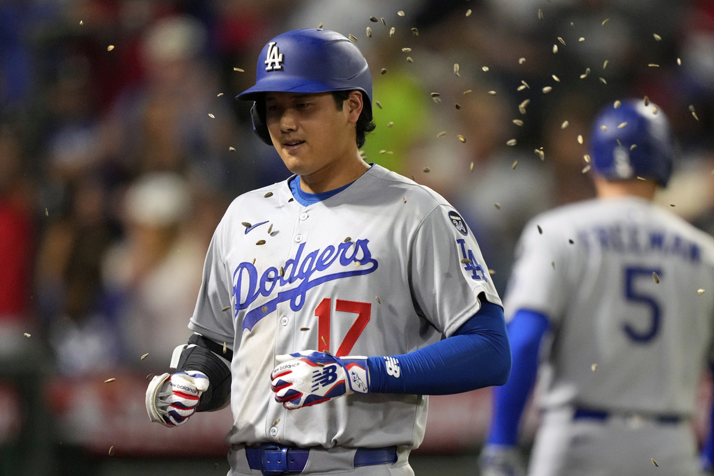 Los Angeles Dodgers' Shohei Ohtani, right, is hit with seeds after hitting a solo home run during the ninth inning of a baseball game against the Los Angeles Angels, Tuesday, Aug. 12, 2025, in Anaheim, Calif. (AP Photo/Mark J. Terrill)