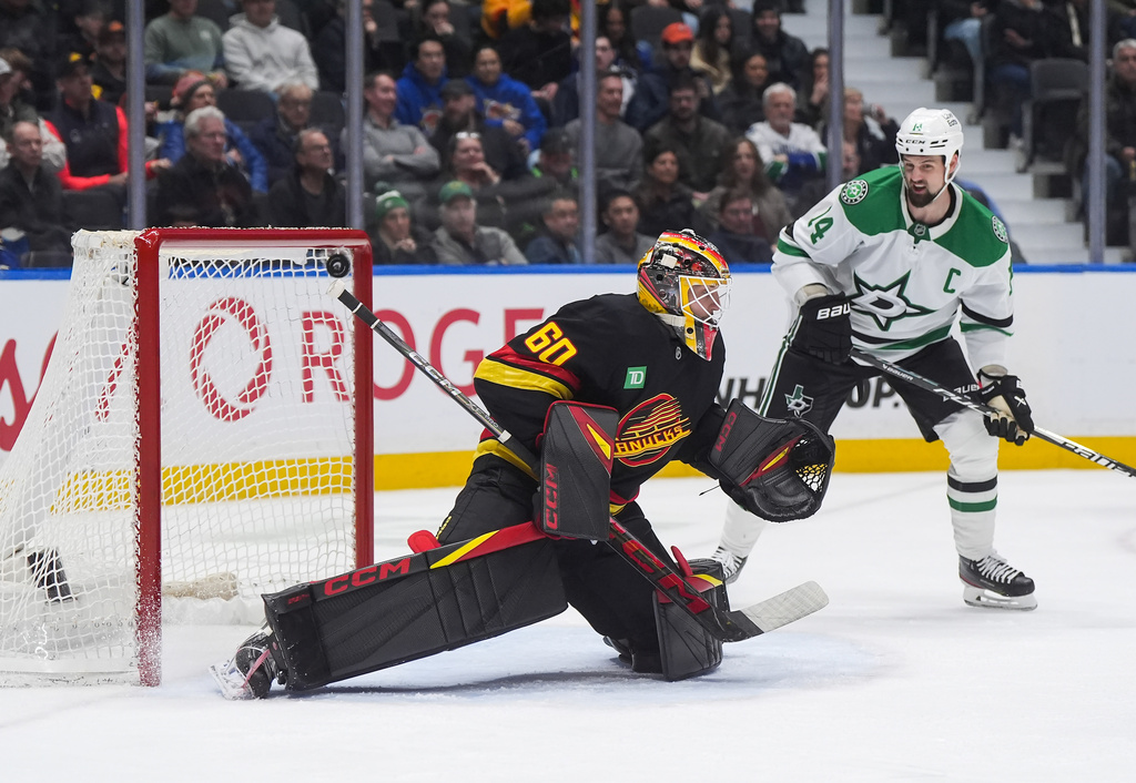 Vancouver Canucks goalie Nikita Tolopilo (60) allows a goal to Dallas Stars' Lian Bichsel, not seen, as Jamie Benn (14) watches during the second period of an NHL hockey game, in Vancouver, on Monday, March 2, 2026. (Darryl Dyck/The Canadian Press via AP)