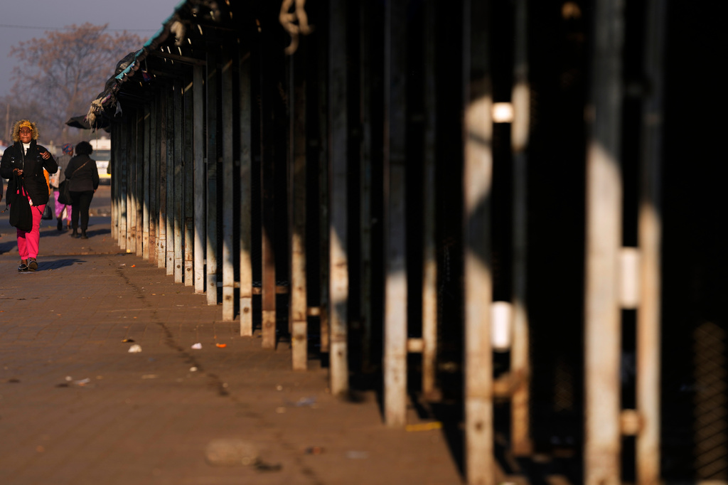 A woman walks past empty market stalls in Thokoza township, east of Johannesburg, South Africa, Tuesday, June 30, 2026. (AP Photo/Themba Hadebe)
