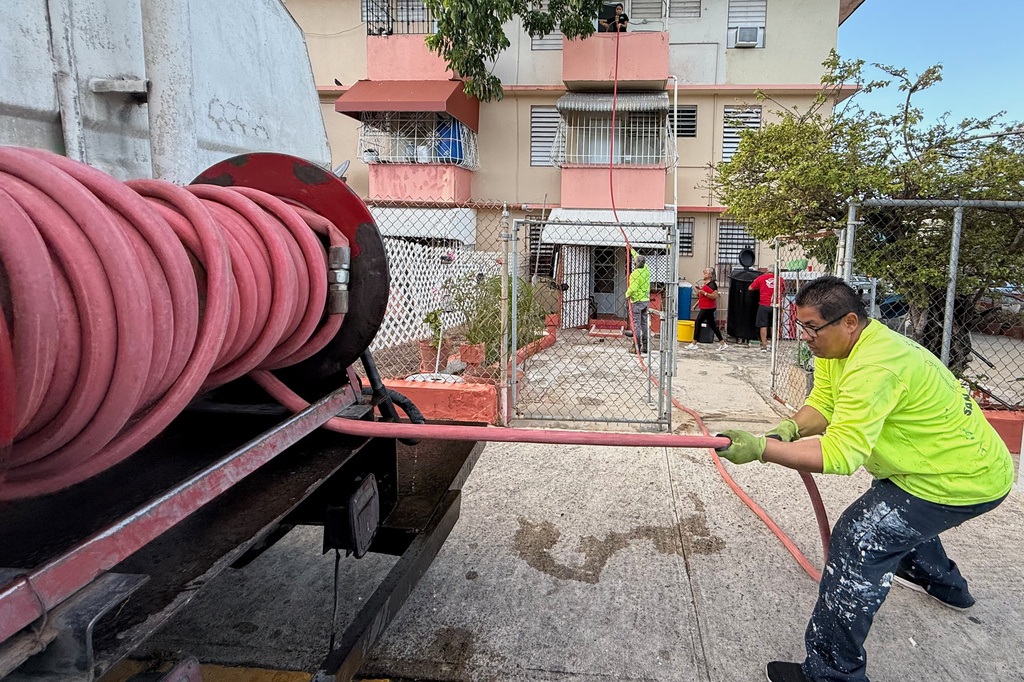 Juan Lugo, a driver with San Juan's special projects department, delivers free, non-potable water to residents in the Villa Kennedy public housing complex in San Juan, Puerto Rico, Wednesday, June 10, 2026. (AP Photo/Danica Coto)