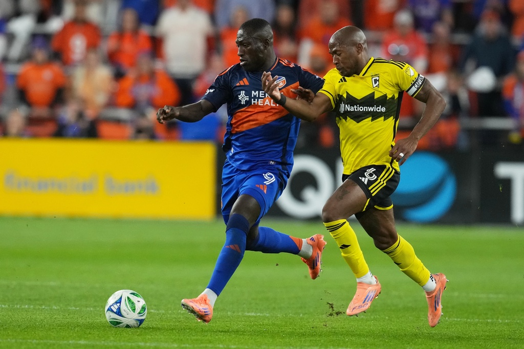 FC Cincinnati forward Kévin Denkey (9) controls the ball against Columbus Crew midfielder Darlington Nagbe (6) during the first half of Game 3 in the first round of MLS soccer's Eastern Conference playoffs, Saturday, Nov. 8, 2025, in Cincinnati.(AP Photo/Darron Cummings)