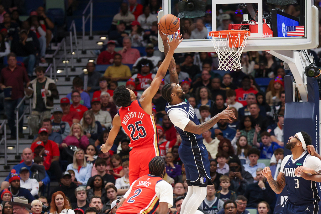 New Orleans Pelicans forward Trey Murphy III (25) and Dallas Mavericks forward Naji Marshall (13) both fight for the ball in the first half of an NBA basketball game Monday, Dec. 22, 2025, in New Orleans. (AP Photo/Peter Forest)