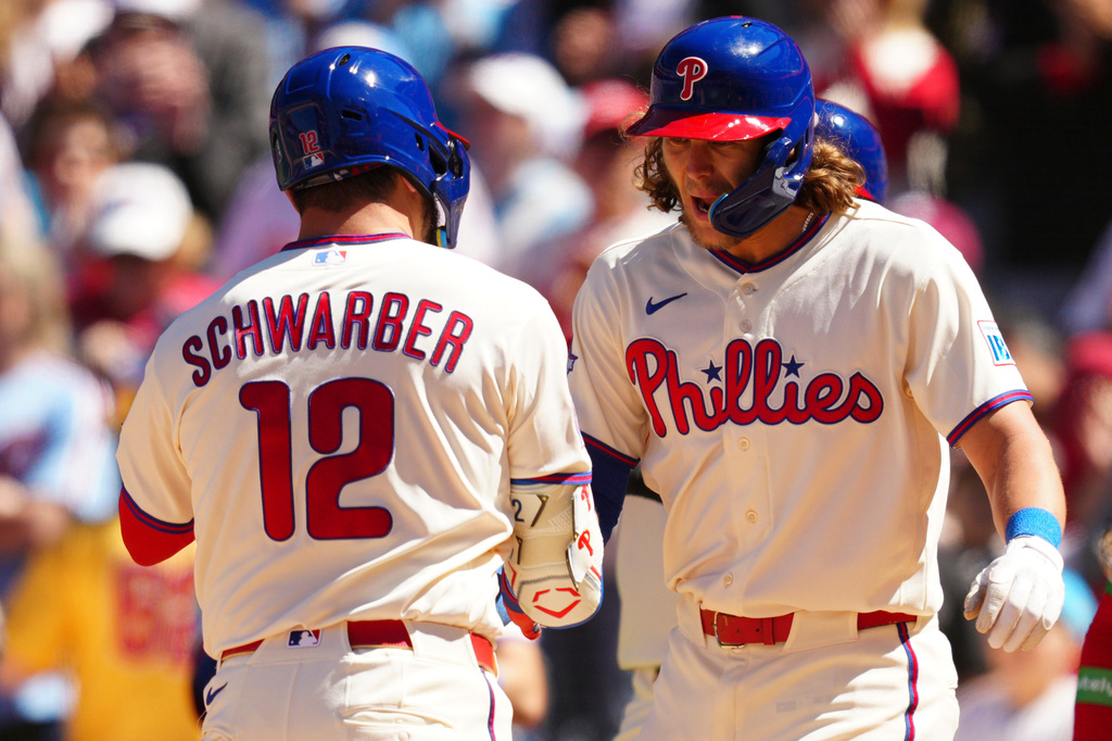 Philadelphia Phillies' Kyle Schwarber (12) celebrates his three-run home run off Arizona Diamondbacks pitcher Brandon Pfaadt with Alec Bohm, right, during the third inning of a baseball game, Saturday, April 11, 2026, in Philadelphia. (AP Photo/Derik Hamilton)