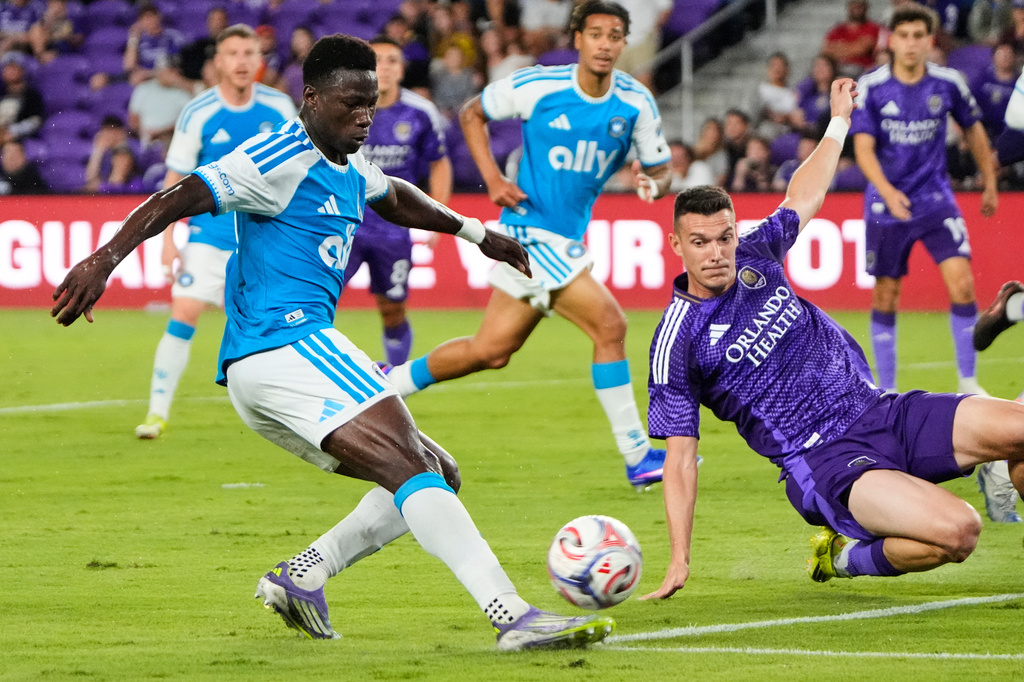 Charlotte FC forward Rodolfo Aloko, left, attempts a shot on goal as Orlando City SC defender Adrian Marin, right, tries to block during the first half of an MLS soccer match, Wednesday, April 22, 2026, in Orlando, Fla. (AP Photo/John Raoux)