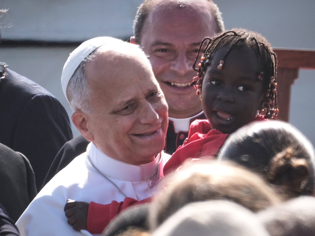 Pope Leo XIV holds a young assistant as he arrives for a meeting with migrants at the Las Raíces reception center in San Cristóbal de La Laguna, Tenerife, Spain, Friday, June 12, 2026. (AP Photo/Arturo Rodriguez)