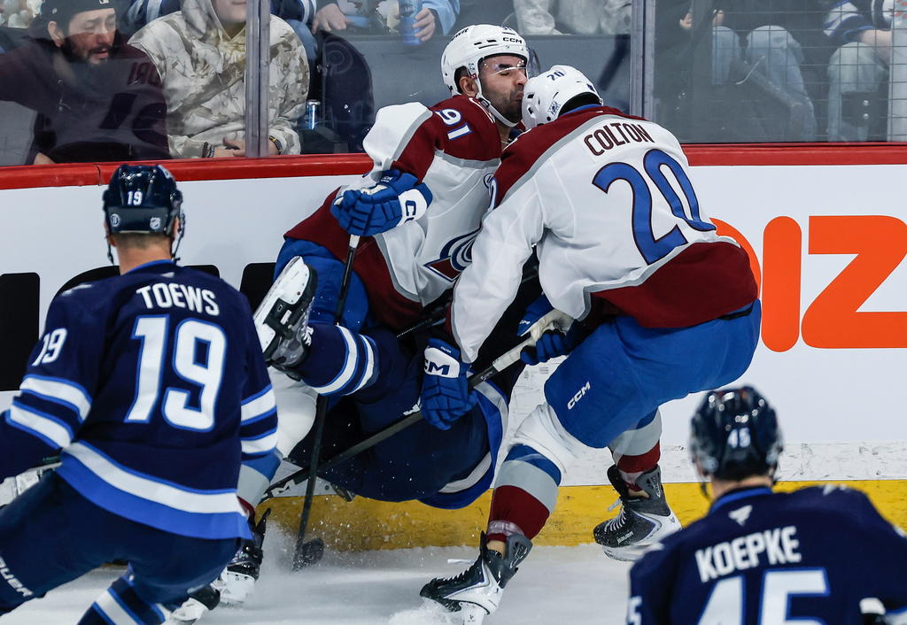 Colorado Avalanche's Gabriel Landeskog (92) and Ross Colton (20) collide with Winnipeg Jets' Dylan DeMelo (2) during the first period of an NHL game in Winnipeg, Thursday, March 26, 2026. (John Woods/The Canadian Press via AP)