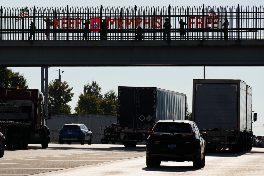 People demonstrate above Interstate 40 in Nashville, Tenn., Friday, Sept. 26, 2025, against the deployment of the National Guard in Memphis. (AP Photo/George Walker IV)