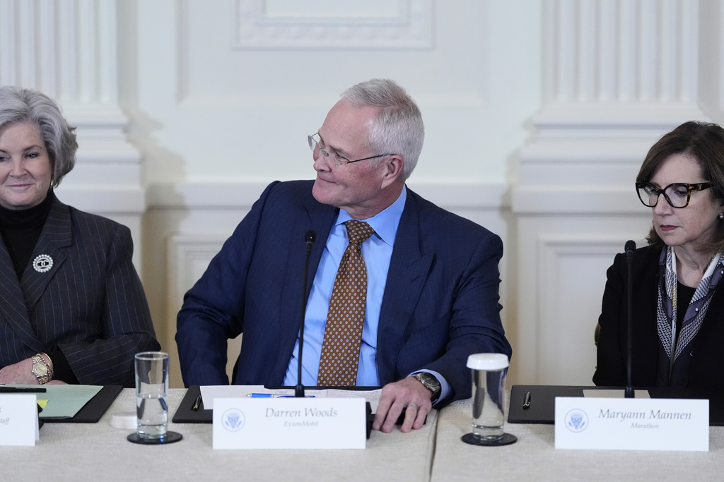 Chief Executive Officer and Chairman of ExxonMobil Darren Woods greets President Donald Trump, not pictured, with White House Chief of Staff Susie Wiles, seated left, and Chairman, President and Chief Executive Officer of Marathon Petroleum Maryann Mannen, seated right, during a meeting in the East Room of the White House, Friday, Jan. 9, 2026, in Washington. (AP Photo/Alex Brandon)