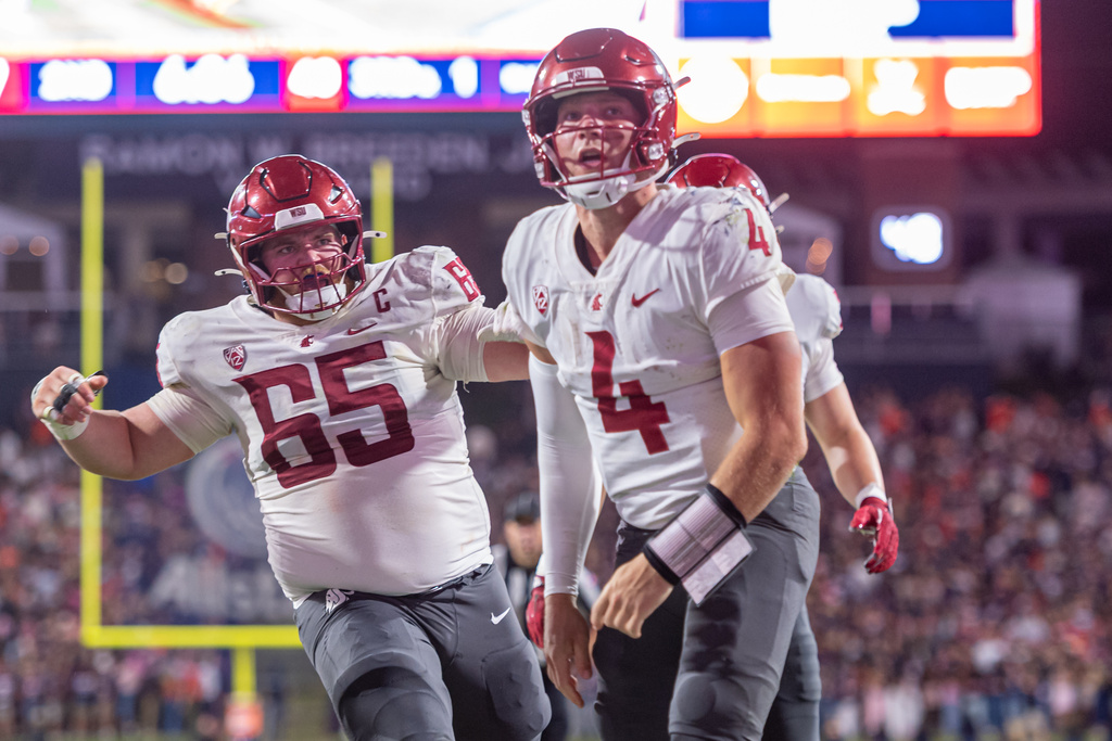 Washington State quarterback Zevi Eckhaus (4) reacts to the crowd after a touchdown against Virginia during the first half of an NCAA college football game, Saturday, Oct. 18 2025, in Charlottesville, Va. (AP Photo/Robert Simmons)