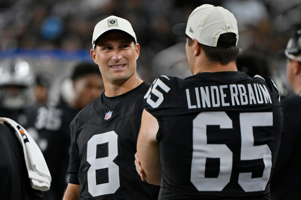 Las Vegas Raiders quarterback Kirk Cousins (8) talks with Raiders center Tyler Linderbaum (65) on the sideline during the second half of a preseason NFL football game against the Arizona Cardinals, Thursday, Aug. 13, 2026, in Las Vegas. (AP Photo/David Becker)
