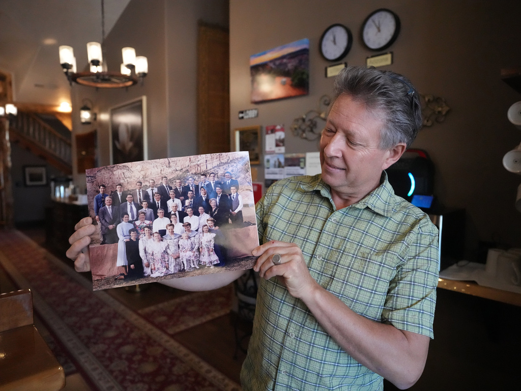 Shem Fischer, owner of the Zion Cliff Lodge, holds a photograph of the Fischer family reunion taken in 1995, during an interview Friday, Dec. 5, 2025, Hildale, Utah. (AP Photo/Rick Bowmer)