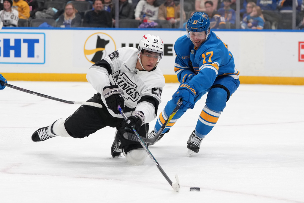Los Angeles Kings' Quinton Byfield (55) and St. Louis Blues' Cam Fowler (17) battle for a loose puck during the third period of an NHL hockey game Saturday, Jan. 24, 2026, in St. Louis. (AP Photo/Jeff Roberson)