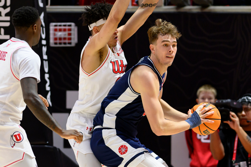 Arizona center Motiejus Krivas, right, posts up against Utah forward James Okonkwo, center, during the first half of an NCAA college basketball game, Saturday, Jan. 3, 2026, in Salt Lake City. (AP Photo/Tyler Tate)