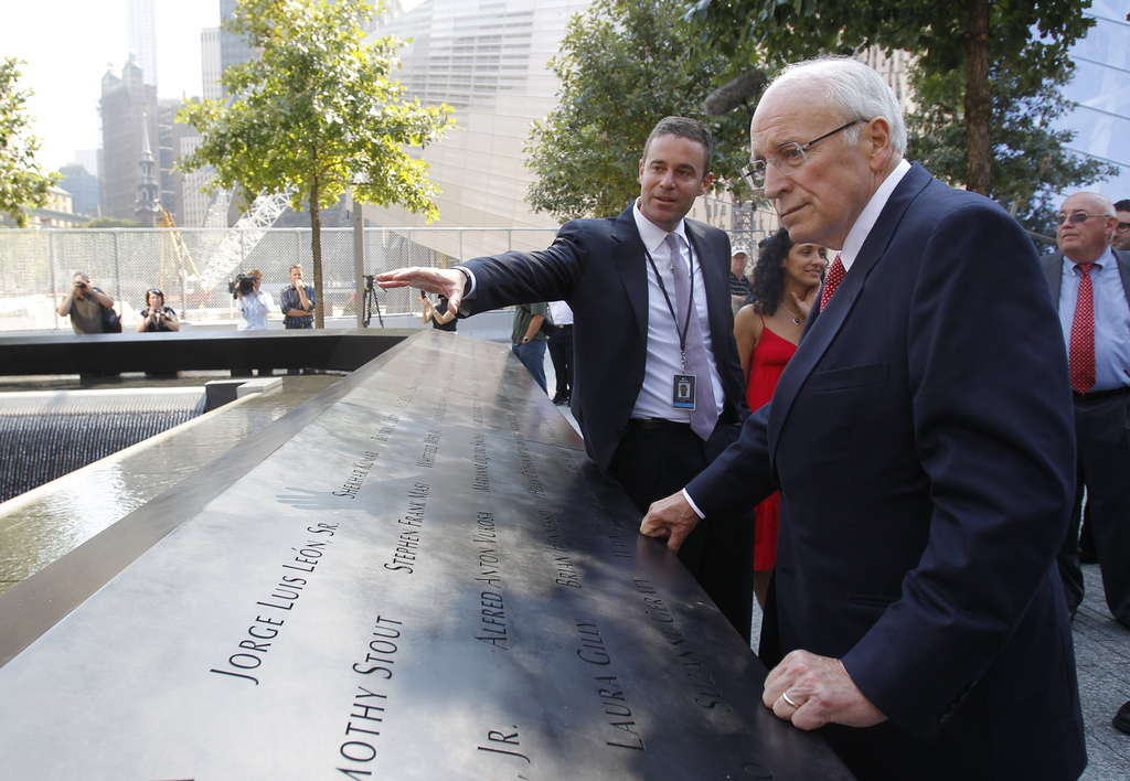 FILE - Former U.S. Vice President Dick Cheney, right, listens to 9/11 Memorial President Joe Daniels, center, as he looks at one of the panels inscribed with the names of the attack victims during a visit to the 9/11 memorial plaza in the World Trade Center site in New York Monday, Sept. 12, 2011, on the first day that the memorial was opened to the public. (AP Photo/Mike Segar, file)
