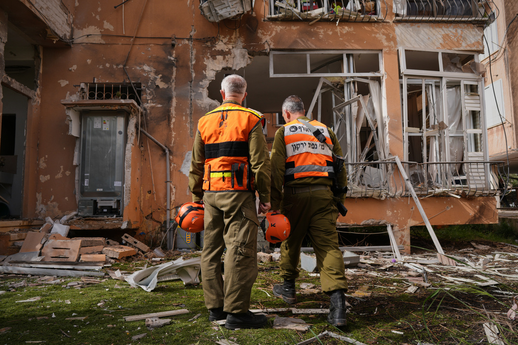 Israeli security forces inspect damage at an apartment building struck by an Iranian missile in Petah Tikva, Israel, Saturday, April 4, 2026. (AP Photo/Maya Levin)