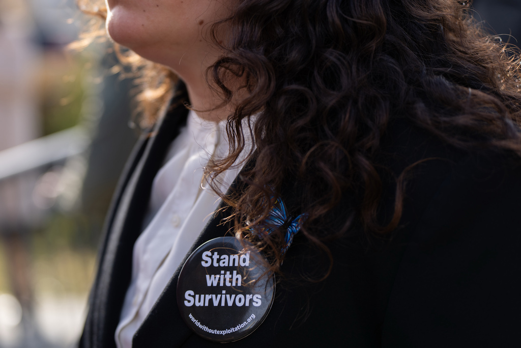 A woman wears a pin during a news conference on the Epstein Files Transparency Act, Tuesday, Nov. 18, 2025, outside the U.S. Capitol in Washington. (AP Photo/Julia Demaree Nikhinson)