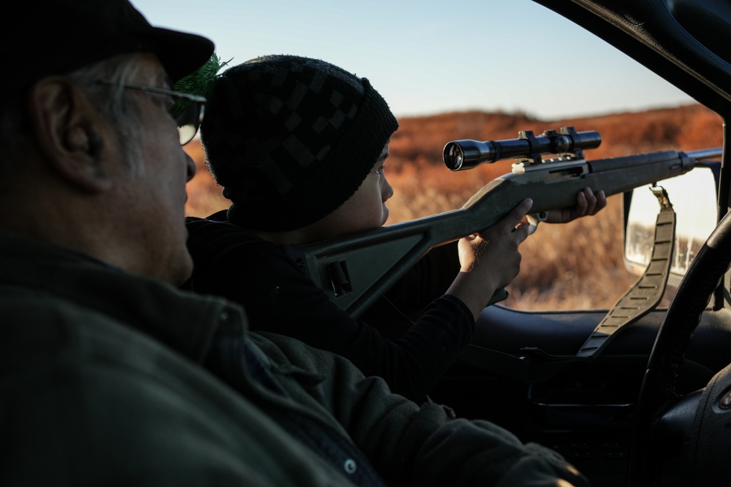 Roswell Schaeffer, an Inupiaq hunter and fisher, helps his great-grandson James Schaeffer, 7, scope ducks while hunting in Kotzebue, Alaska, Friday, Sept. 26, 2025. (AP Photo/Annika Hammerschlag)