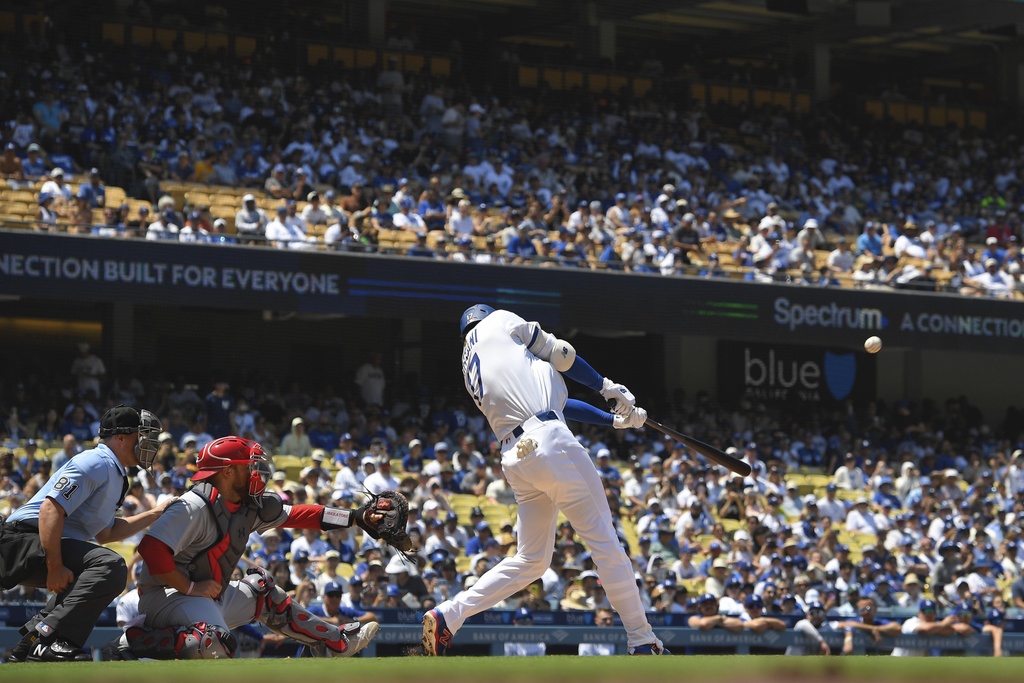 Los Angeles Dodgers' Shohei Ohtani, right, hits a two-run home run and his 1,000th hit as St. Louis Cardinals catcher Pedro Pages watches during the third inning of a baseball game Wednesday, Aug. 6, 2025, in Los Angeles. (AP Photo/Mark J. Terrill)