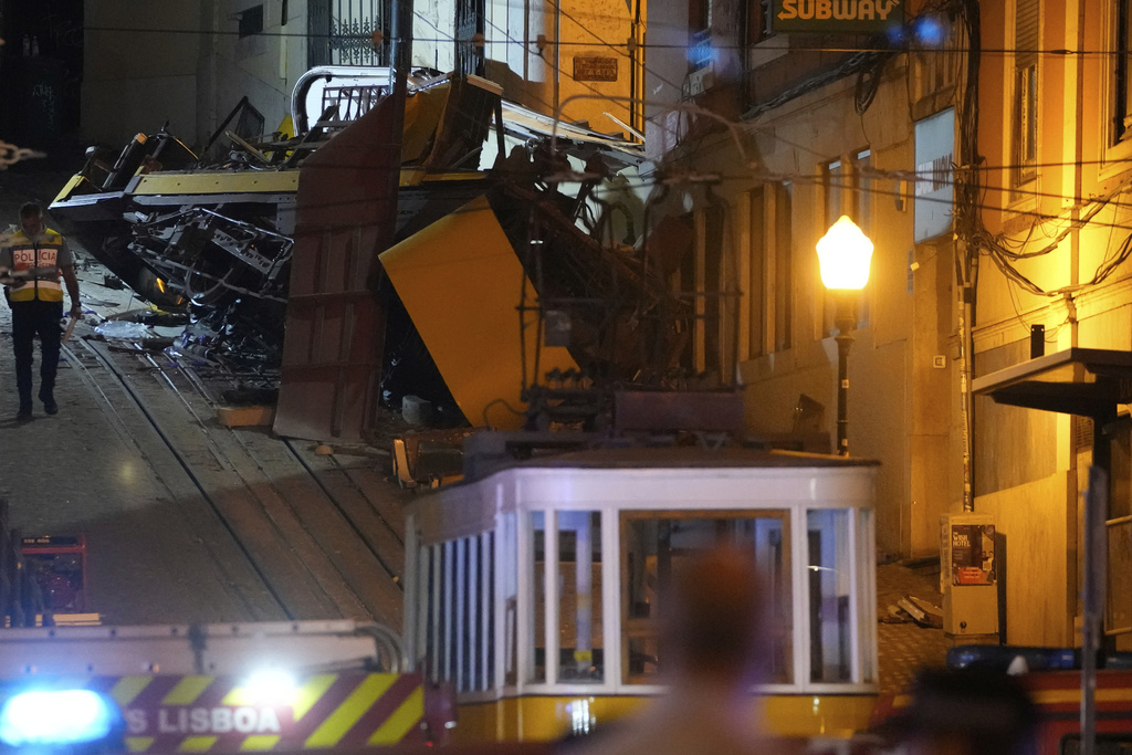 A police officer walks at the site of a derailed electric streetcar in Lisbon, Portugal, Wednesday, Sept. 3, 2025. (AP Photo/Armando Franca)