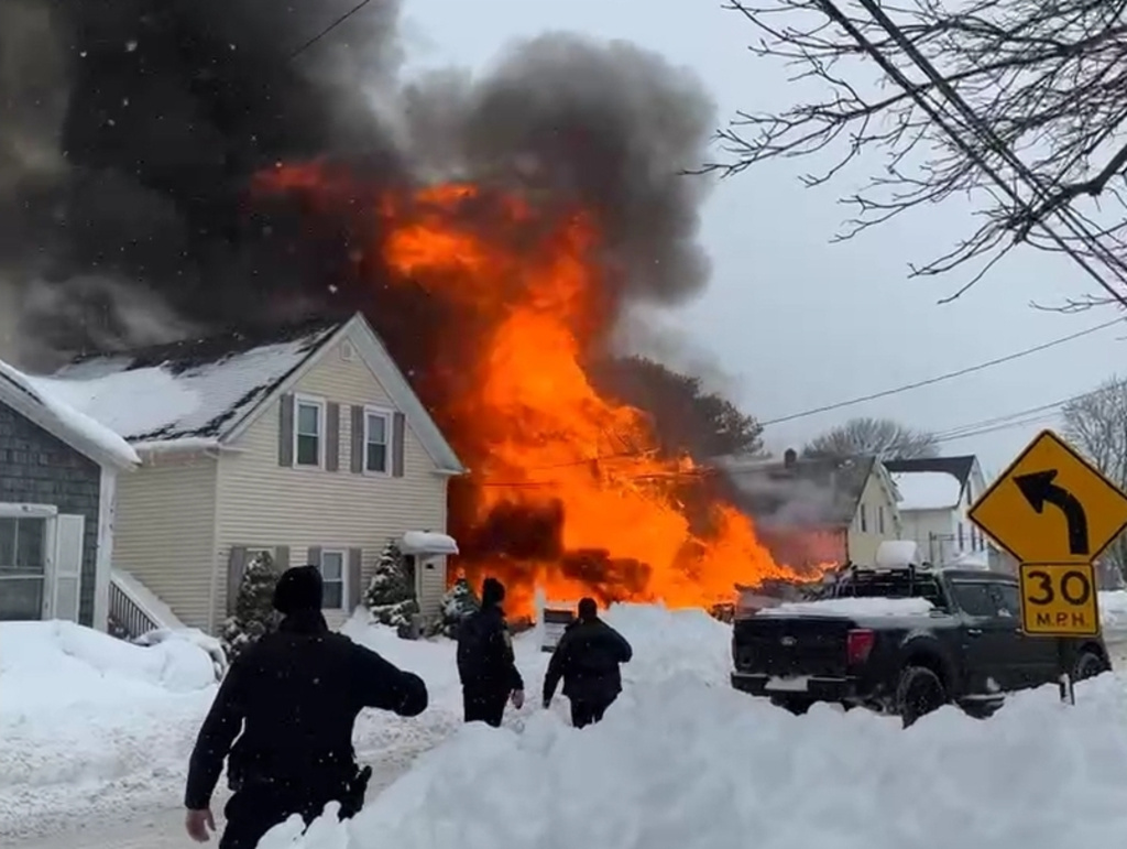 Firefighters respond to a home engulfed in flames on Wednesday, Feb. 25, 2026, in Taunton, Mass. (William James Shivers Jr. via AP)