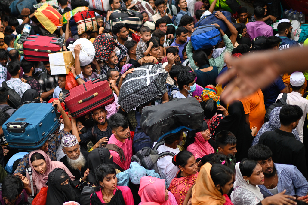 Thousands of travelers scramble and jostle each other to board ferries at the Sadarghat Launch Terminal, joining the massive annual exodus to celebrate Eid al-Fitr in their hometowns, in Dhaka, Bangladesh, Wednesday, March 18, 2026. (AP Photo/Mahmud Hossain Opu)