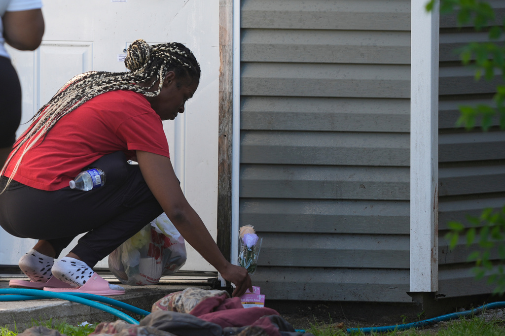 People leave flowers at the door outside the scene of a mass shooting, Sunday, April 19, 2026, in Shreveport, La. (AP Photo/Gerald Herbert)