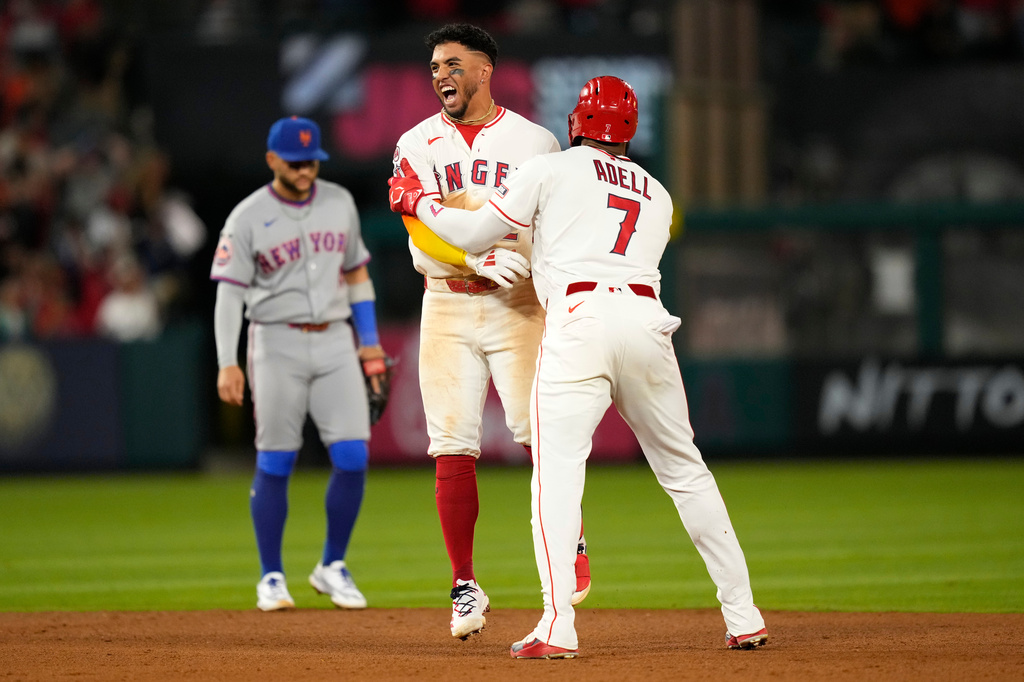 Los Angeles Angels' Oswald Peraza, center, celebrates his walk off single with Jo Adell, right, as New York Mets' Bo Bichette walks off the field in the 10th inning of a baseball game Saturday, May 2, 2026, in Anaheim, Calif. (AP Photo/Mark J. Terrill)