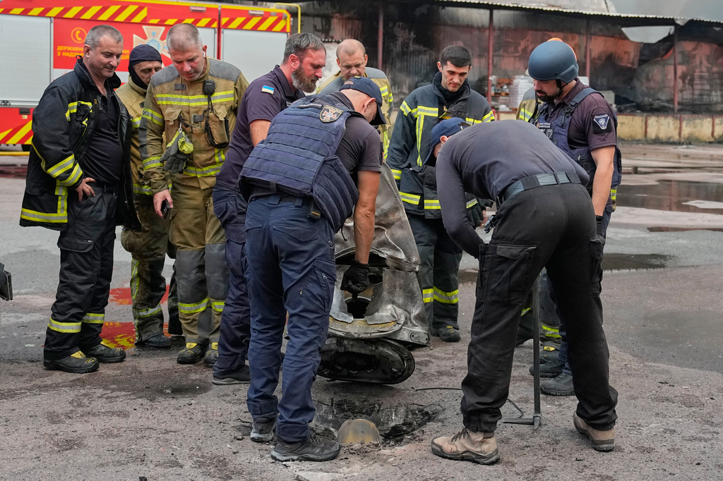 Firefighters examine a fragment of a Russian missile after air strikes at a food warehouse in Kyiv, Ukraine, Wednesday, Aug. 5, 2026. (AP Photo/Efrem Lukatsky)